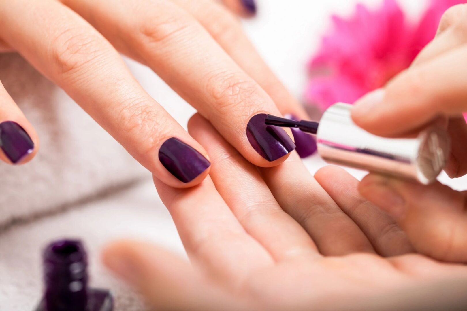 A person is painting their nails purple