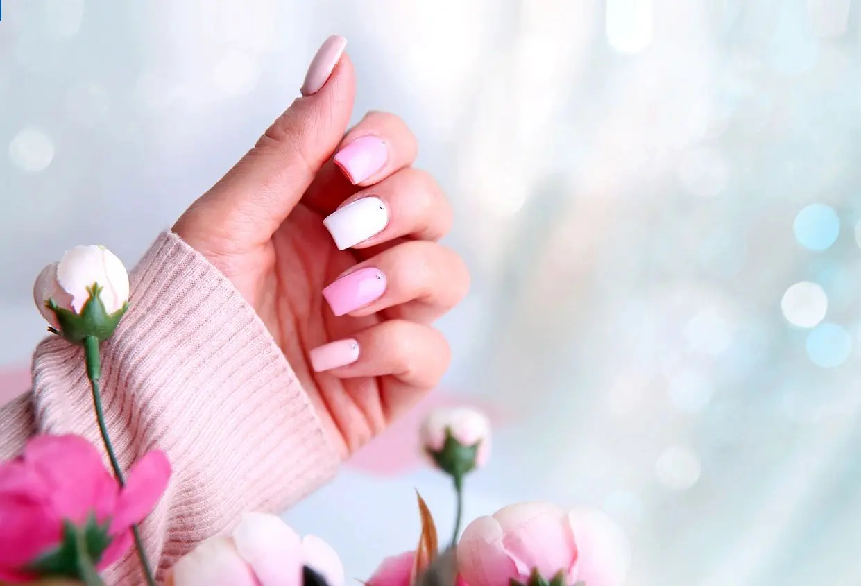 A woman with her hands up and pink nails